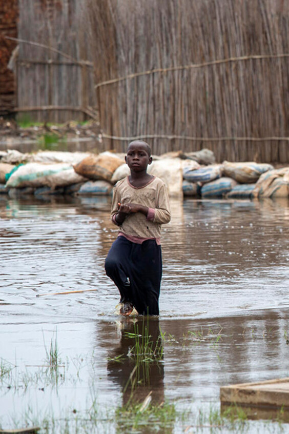 Un enfant marche à travers les inondations